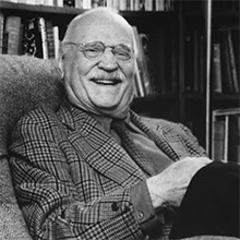 Frank W. Cyr sitting in a chair, smiling.